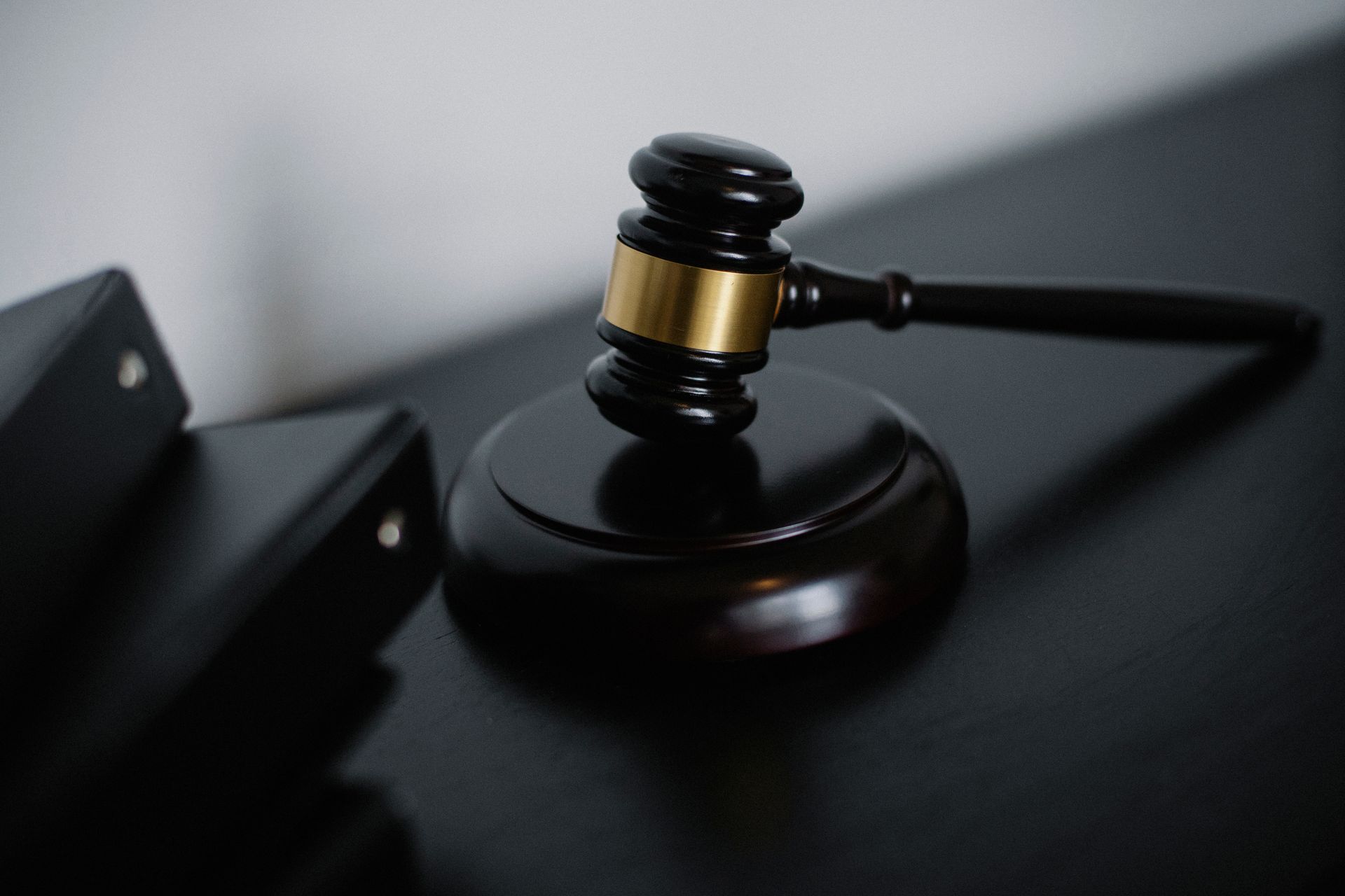 Wooden gavel on a courthouse table beside stacked document folders